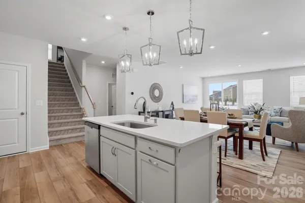 a very nice looking dining room with wooden floor and white cabinets