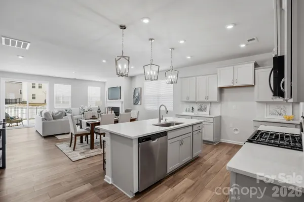 a kitchen with a stove a sink a dining table and chairs