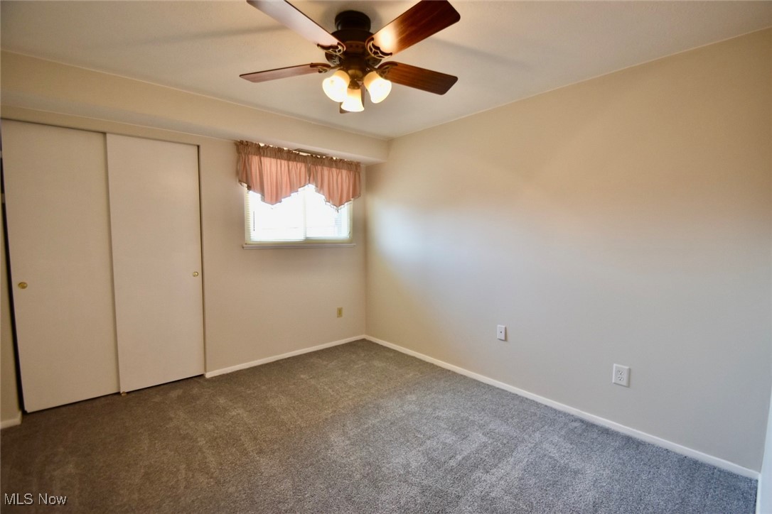 8955 West Ridge Road, Unit D Elyria, OH 44035 - Photo 26 of 33 Unfurnished bedroom featuring carpet, a closet, and ceiling fan
