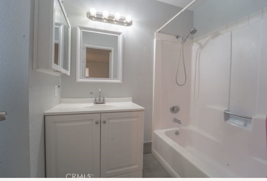 15032 Birch Street Hesperia, CA 92345 - Photo 16 of 21 a bathroom with a granite countertop sink a toilet a mirror a vanity and shower