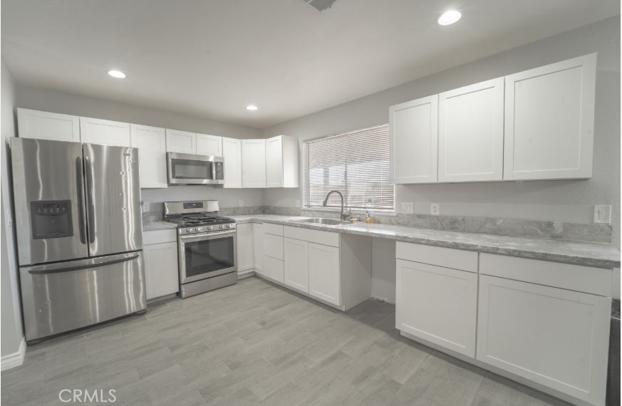 15032 Birch Street Hesperia, CA 92345 - Photo 7 of 21 a kitchen with granite countertop white cabinets and stainless steel appliances