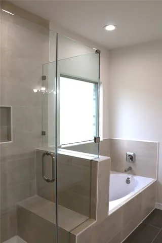 a bathroom with a tub sink and mirror