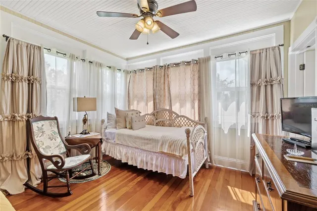 a bedroom with a bed and wooden floor