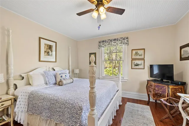 a bedroom with a bed a flat screen tv and a chandelier