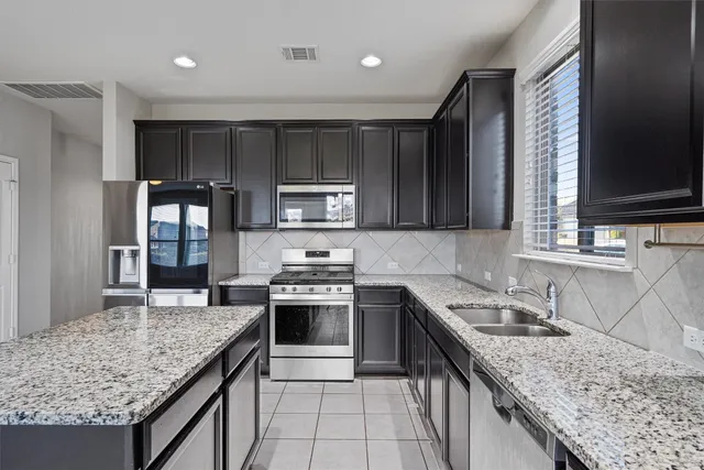 a kitchen with stainless steel appliances granite countertop a sink stove and oven