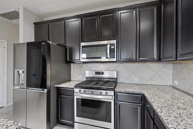 a kitchen with granite countertop stainless steel appliances and wooden cabinets