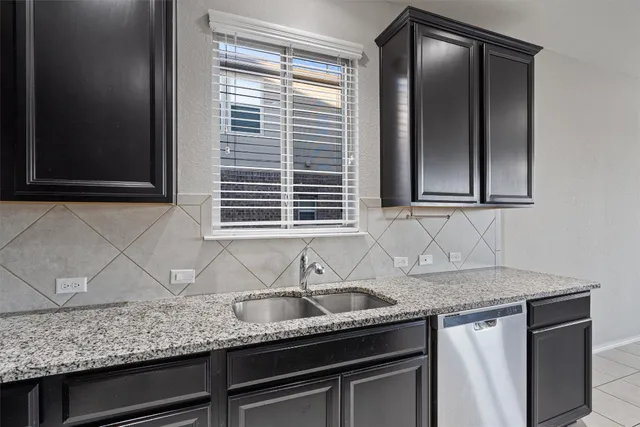 a kitchen with granite countertop cabinets sink and window