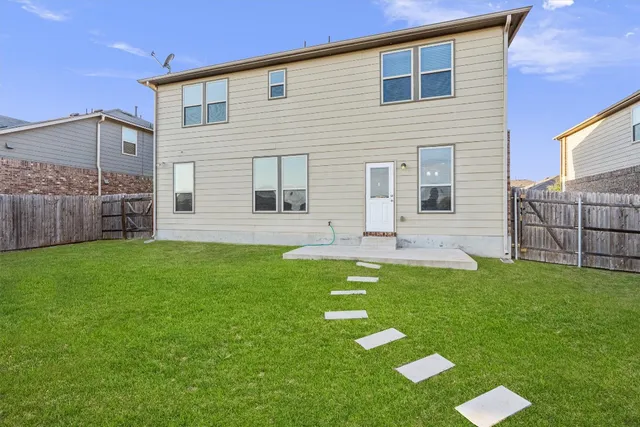 a backyard of a house with table and chairs