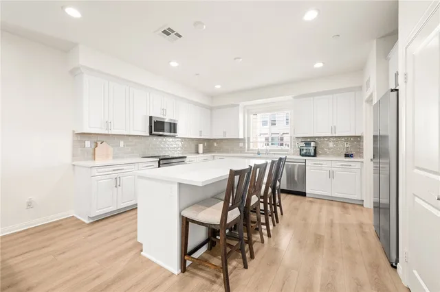 a kitchen with white cabinets and white appliances