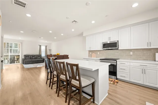 a kitchen with a dining table chairs microwave and cabinets