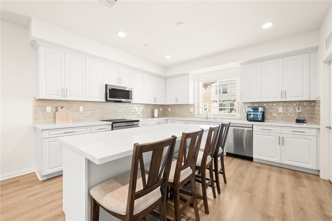 8633 Amherst Street Santee, CA 92071 - Photo 17 of 61 a kitchen with a dining table chairs microwave and cabinets
