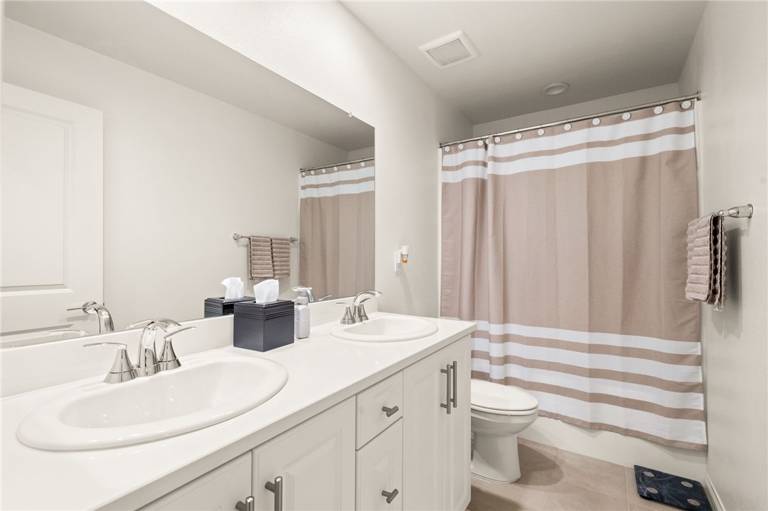 8633 Amherst Street Santee, CA 92071 - Photo 47 of 61 a bathroom with a double vanity sink toilet and a mirror