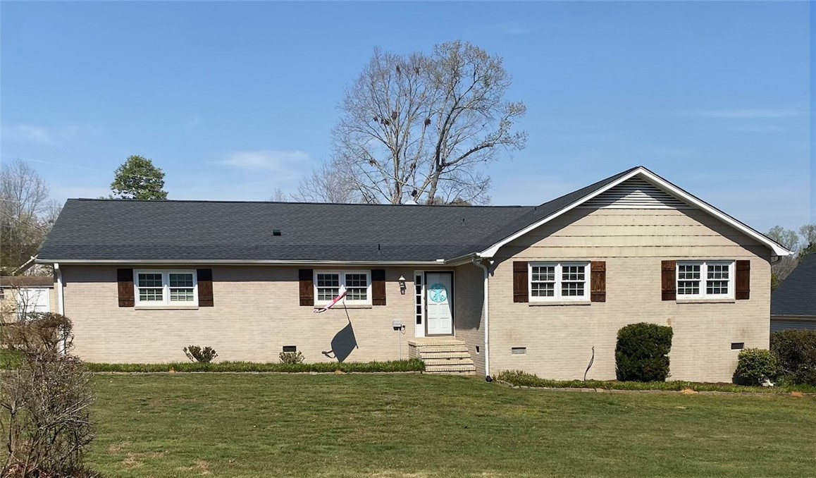 This classic brick residence offers a welcoming facade with charming shuttered windows.