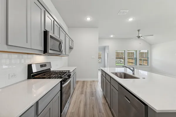 a view of kitchen with stainless steel appliances granite countertop cabinets and wooden floor