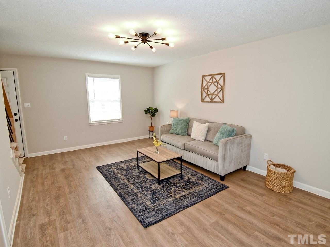 1120 Nottingham Circle Cary, NC 27511 - Photo 7 of 22 a living room with furniture and a chandelier