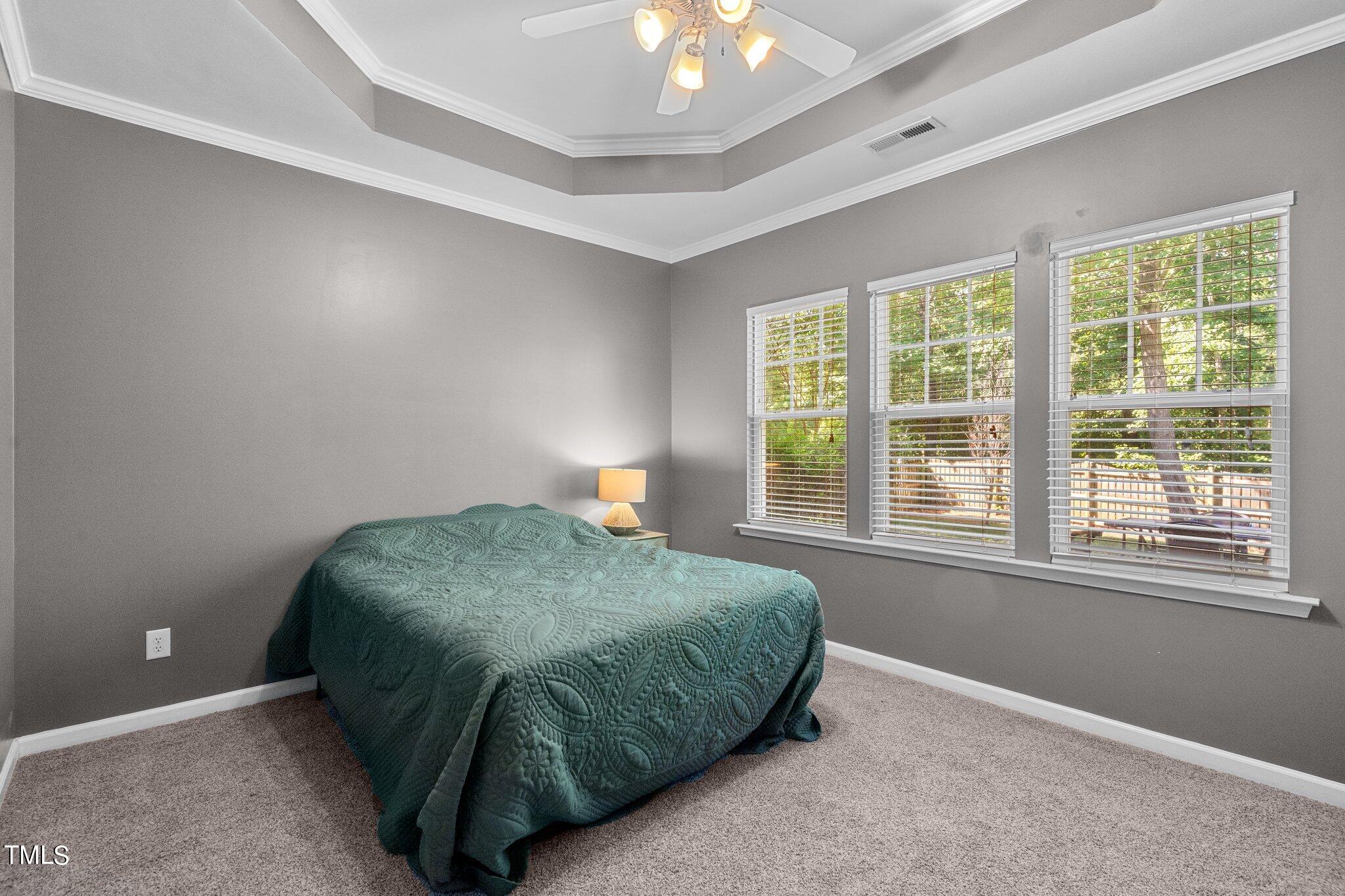 5016 Paperbark Court Durham, NC 27713 - Photo 17 of 35 a bedroom with a bed and a chandelier