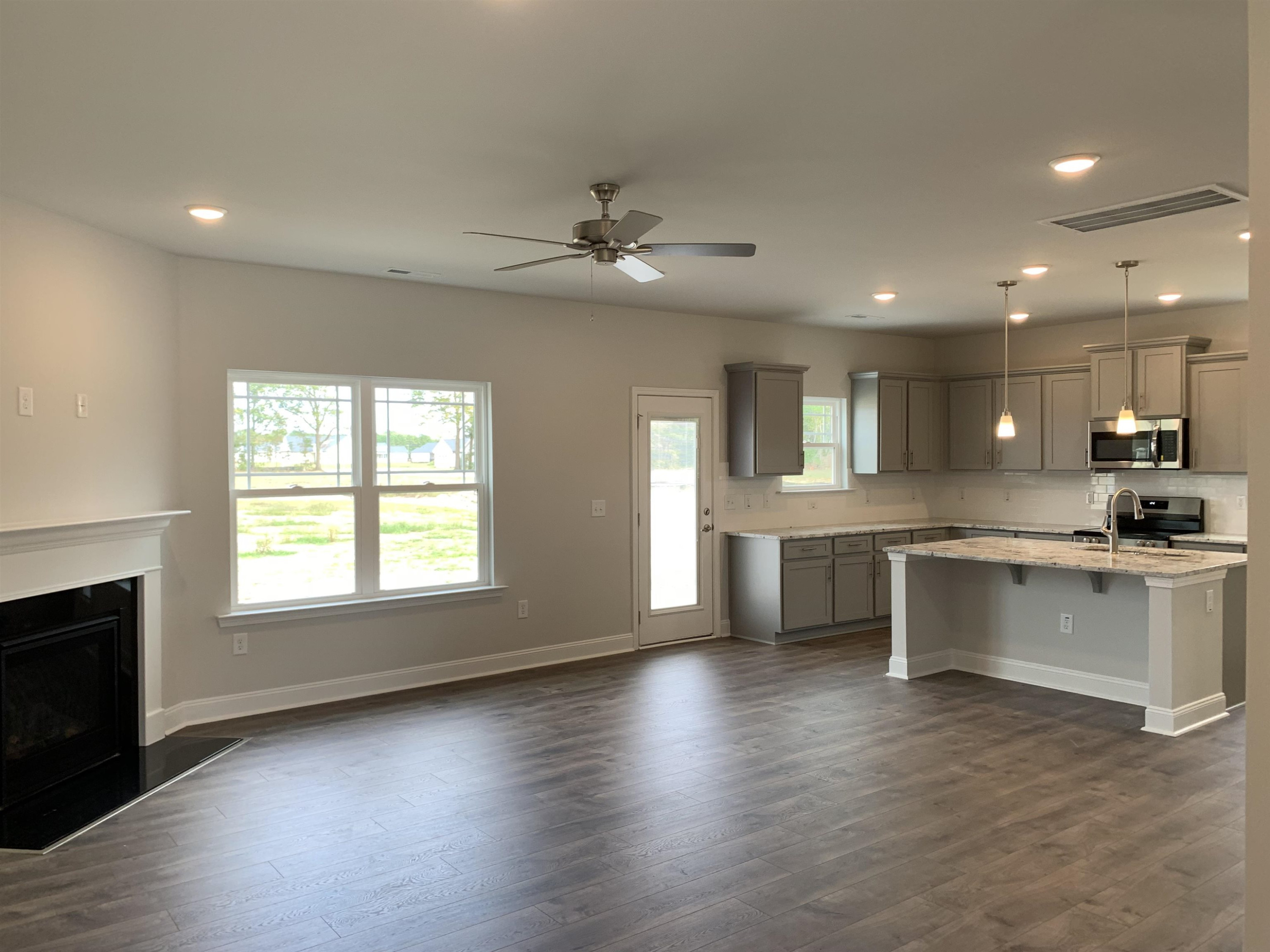 8433 Shallow Crk Trail Bailey, NC 27807 - Photo 3 of 17 an open kitchen with white cabinets and chandelier
