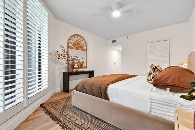 a bedroom with a bed and a large window