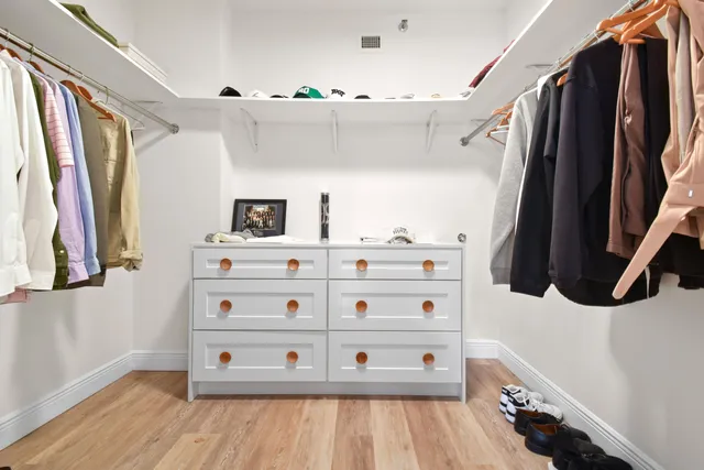 a view of walk in closet with clothes and shoes