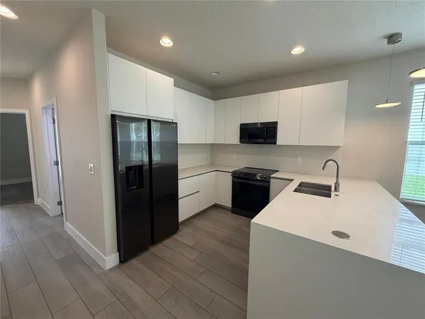a kitchen with stainless steel appliances a refrigerator and a stove top oven