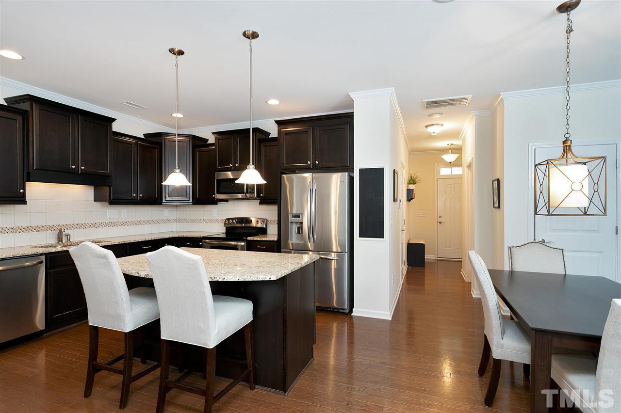 2408 Memory Ridge Drive Raleigh, NC 27606 - Photo 4 of 30 a kitchen with stainless steel appliances granite countertop a kitchen island a table and chairs