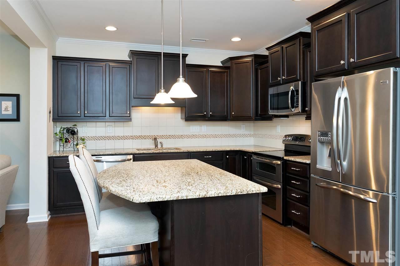 2408 Memory Ridge Drive Raleigh, NC 27606 - Photo 5 of 30 a kitchen with kitchen island a counter top space cabinets and stainless steel appliances