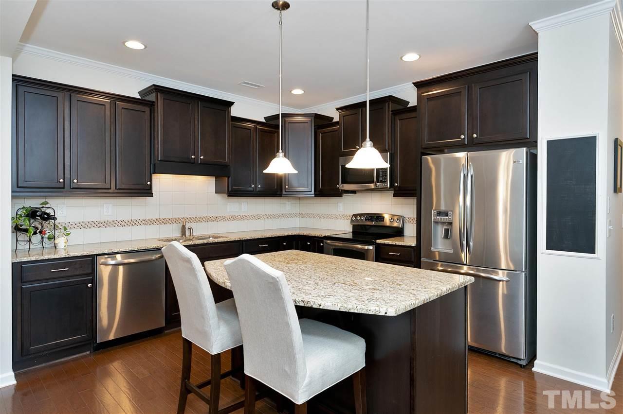 2408 Memory Ridge Drive Raleigh, NC 27606 - Photo 6 of 30 a kitchen with stainless steel appliances granite countertop a sink refrigerator and cabinets