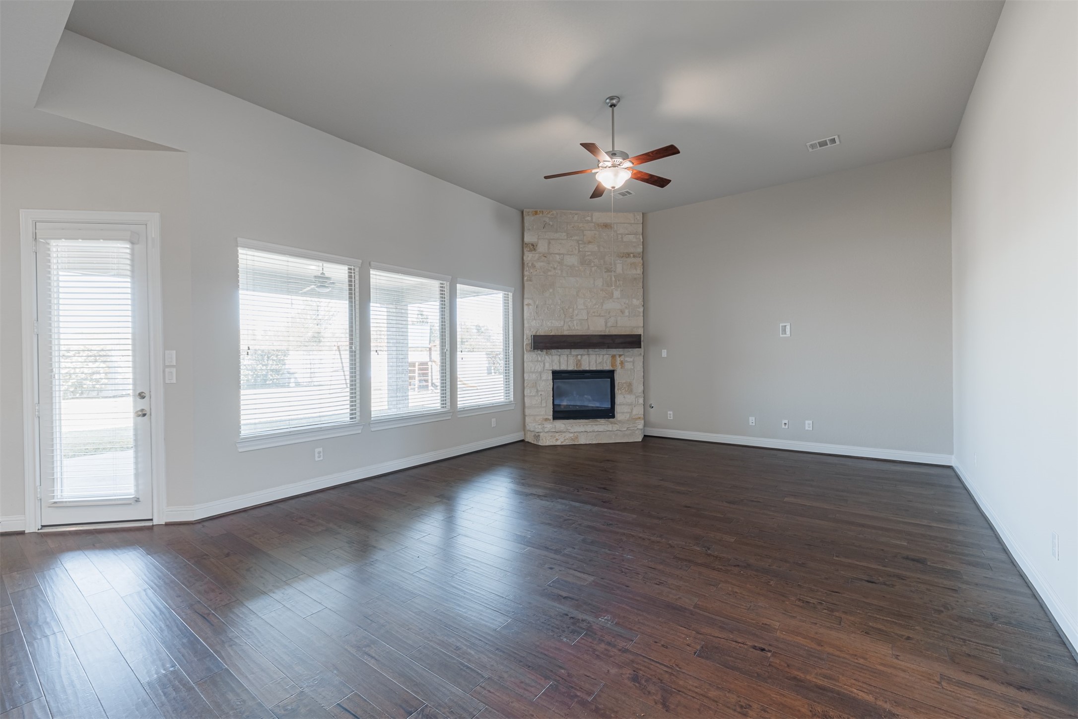 18731 Spellman Ridge Drive Tomball, TX 77377 - Photo 21 of 50 Spacious family room with wood flooring and a striking stone surround gas-log fireplace.