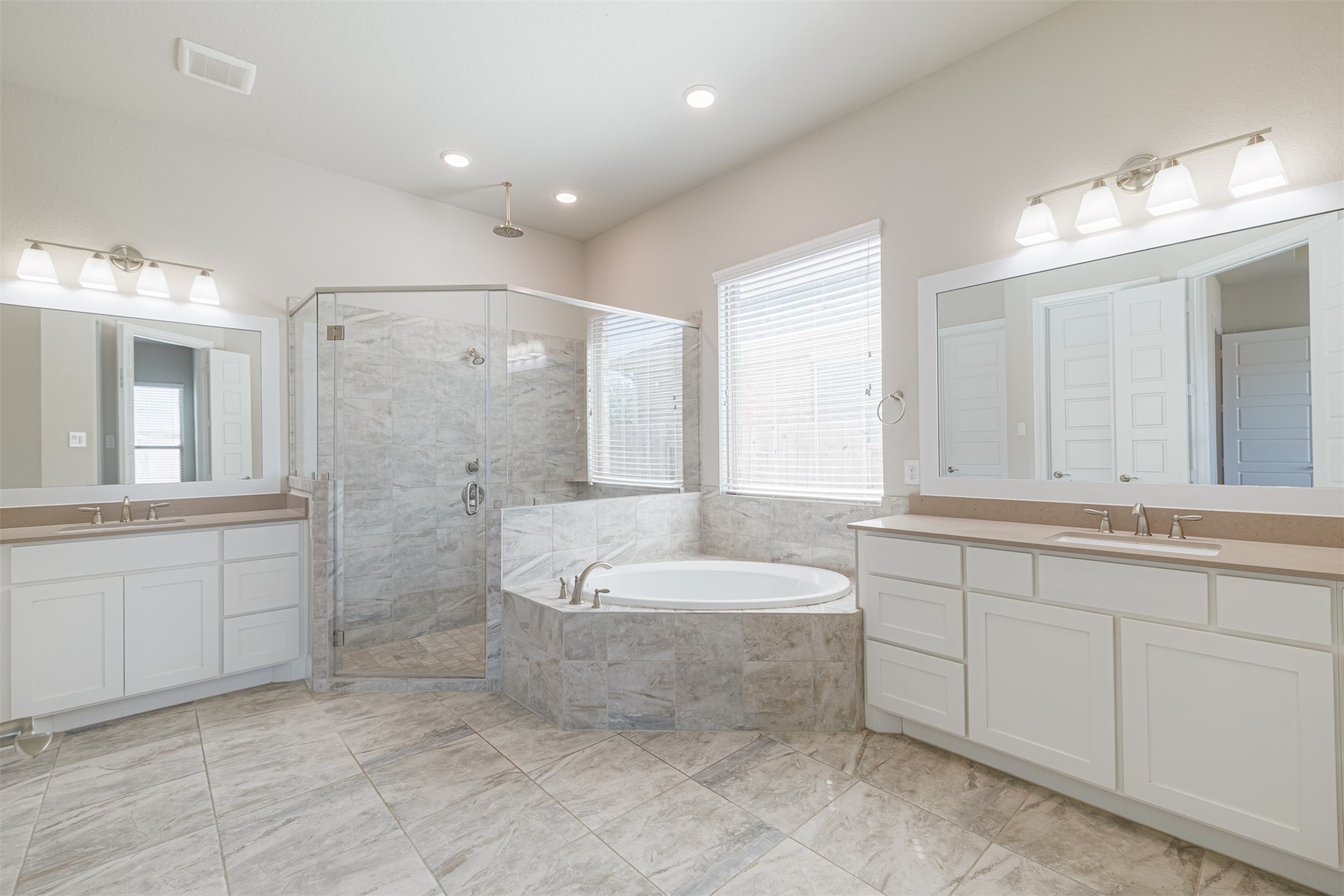 18731 Spellman Ridge Drive Tomball, TX 77377 - Photo 28 of 50 Primary ensuite bath features dual vanities, a soaking tub and a large walk-in shower with seamless glass doors.