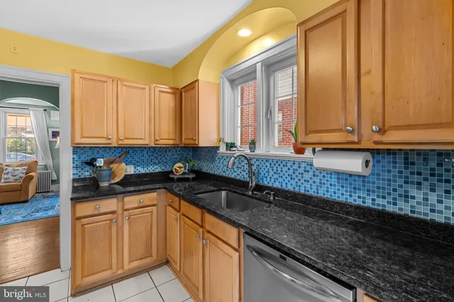a kitchen with granite countertop a sink a stove and cabinets