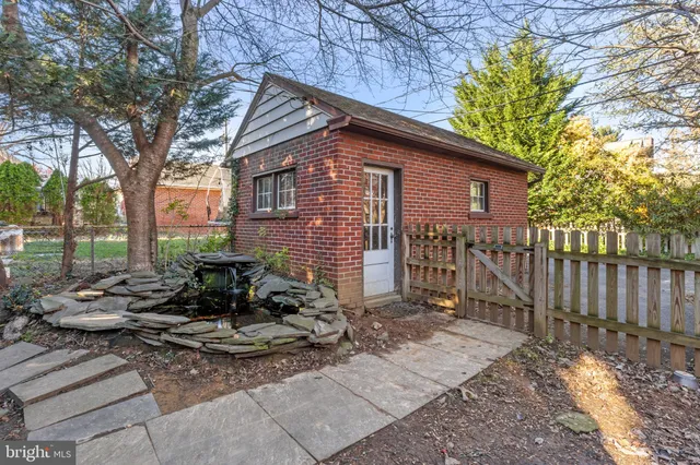 a view of backyard with wooden fence and large trees
