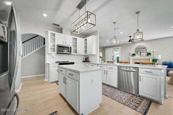 a kitchen with stainless steel appliances granite countertop a refrigerator a stove a sink and a microwave