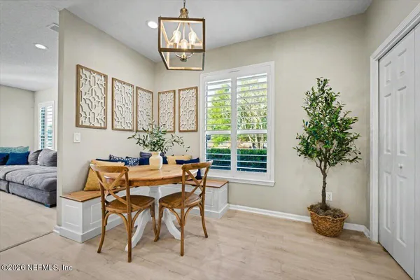 a dining room filled chandelier and wooden floor