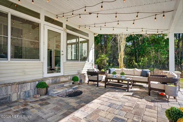 a view of a patio with a table chairs and a backyard