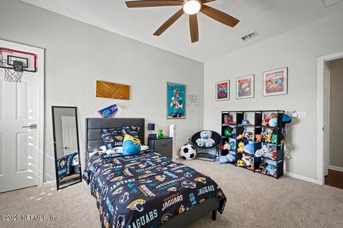 12683 Arrowleaf Lane Jacksonville, FL 32225 - Photo 41 of 52 a bedroom with bed and paintings on the wall