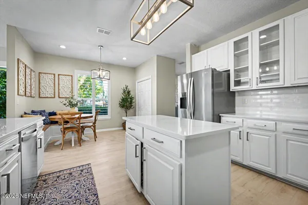 a kitchen with cabinets stainless steel appliances and wooden floor