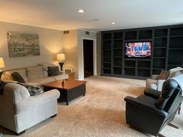 a living room with furniture a projector and a flat screen tv