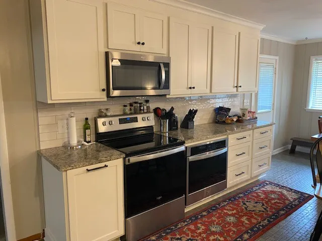 a kitchen with stainless steel appliances granite countertop a stove a sink and a microwave