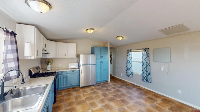 a kitchen with stainless steel appliances granite countertop a sink refrigerator and cabinets