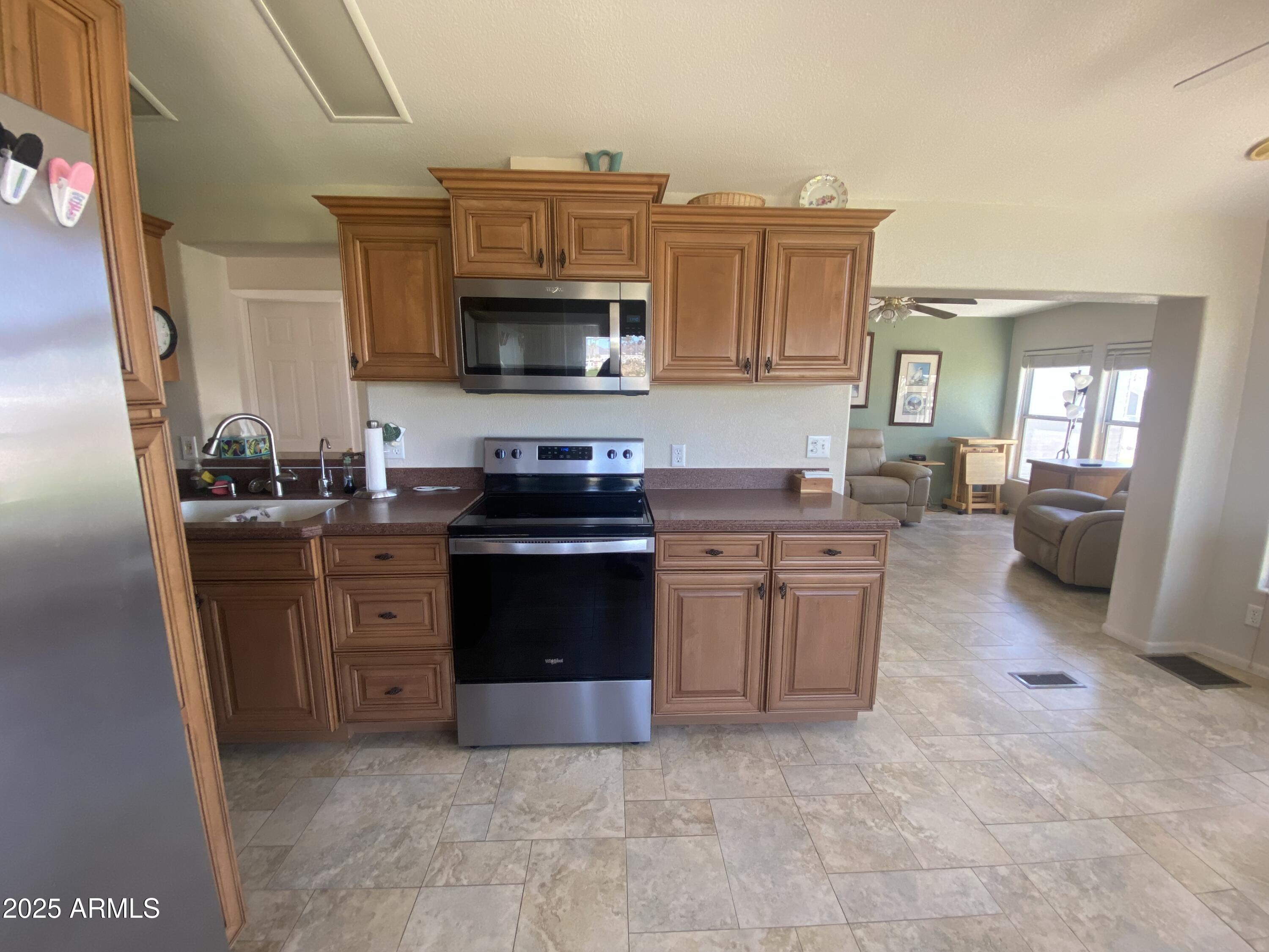 2239 West San Juan Circle Apache Junction, AZ 85119 - Photo 15 of 37 a kitchen with stainless steel appliances granite countertop a stove top oven a sink dishwasher and a refrigerator
