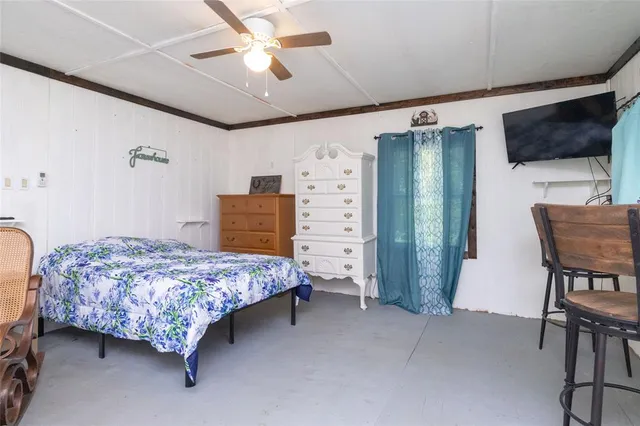 a bedroom with a bed chair and a flat screen tv