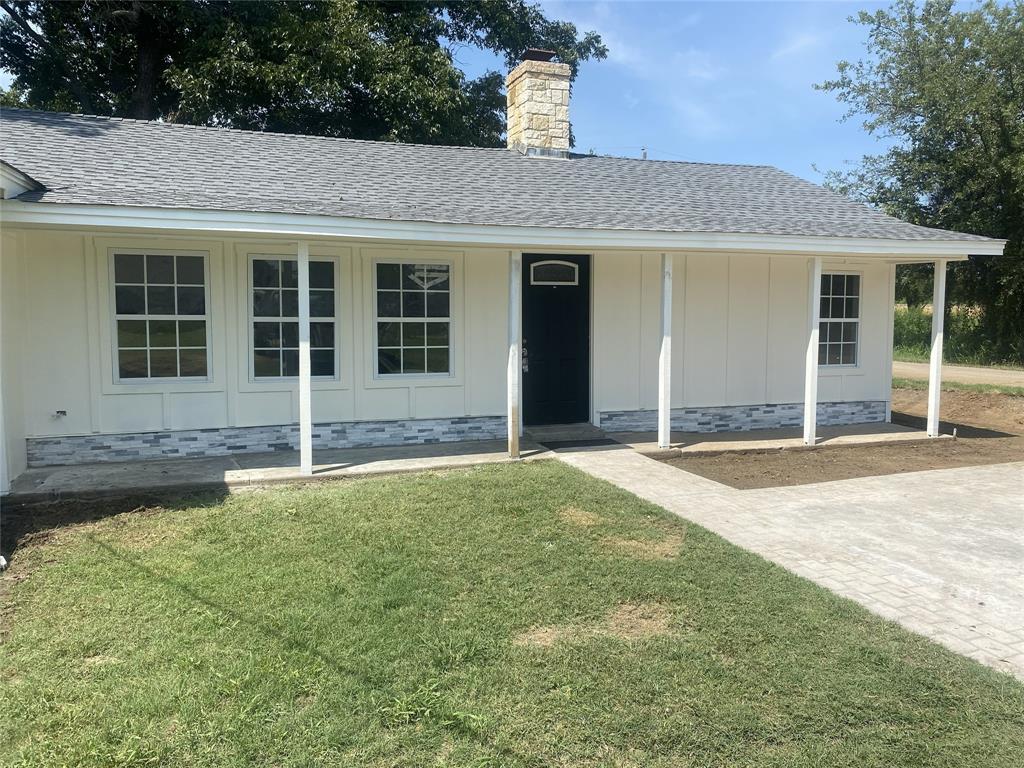 a front view of a house with yard and porch