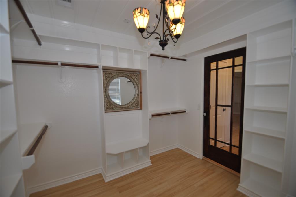 209 West 5th Street Tolar, TX 76476 - Photo 11 of 11 a view of a hallway with wooden floor and chandelier