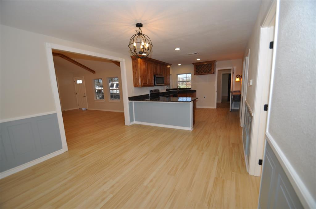 209 West 5th Street Tolar, TX 76476 - Photo 6 of 11 a view of a living room kitchen with furniture and wooden floor