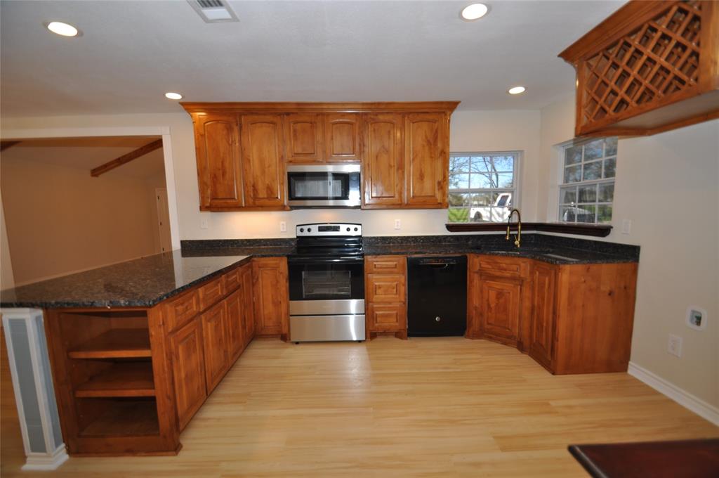209 West 5th Street Tolar, TX 76476 - Photo 7 of 11 a large kitchen with stainless steel appliances granite countertop a stove a sink dishwasher and a refrigerator