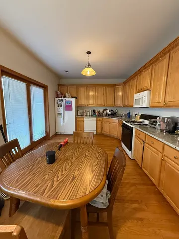 a kitchen with kitchen island a stove a sink a refrigerator dining table and chairs