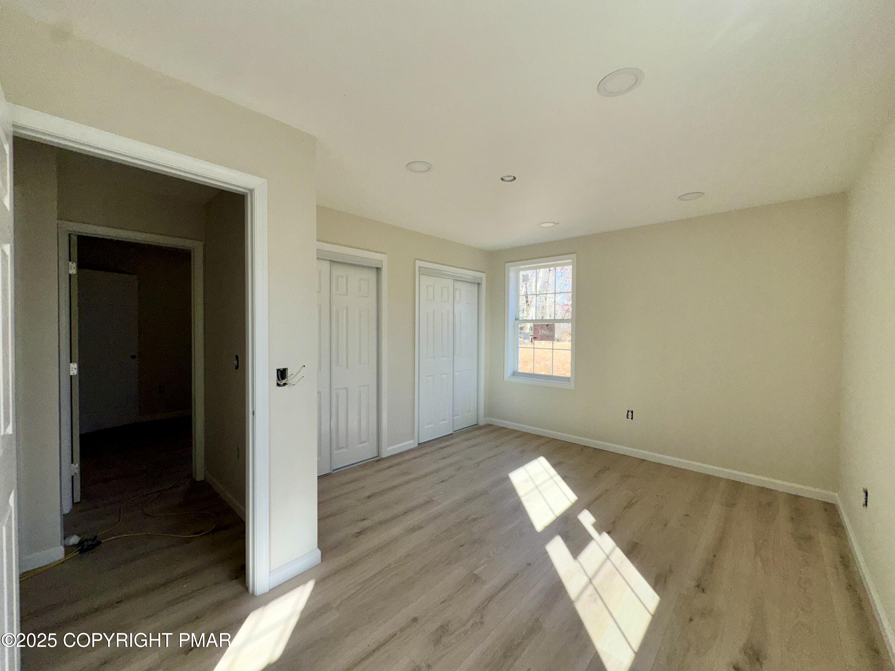 515 Hummingbird Court Bushkill, PA 18324 - Photo 10 of 15 an empty room with wooden floor and windows
