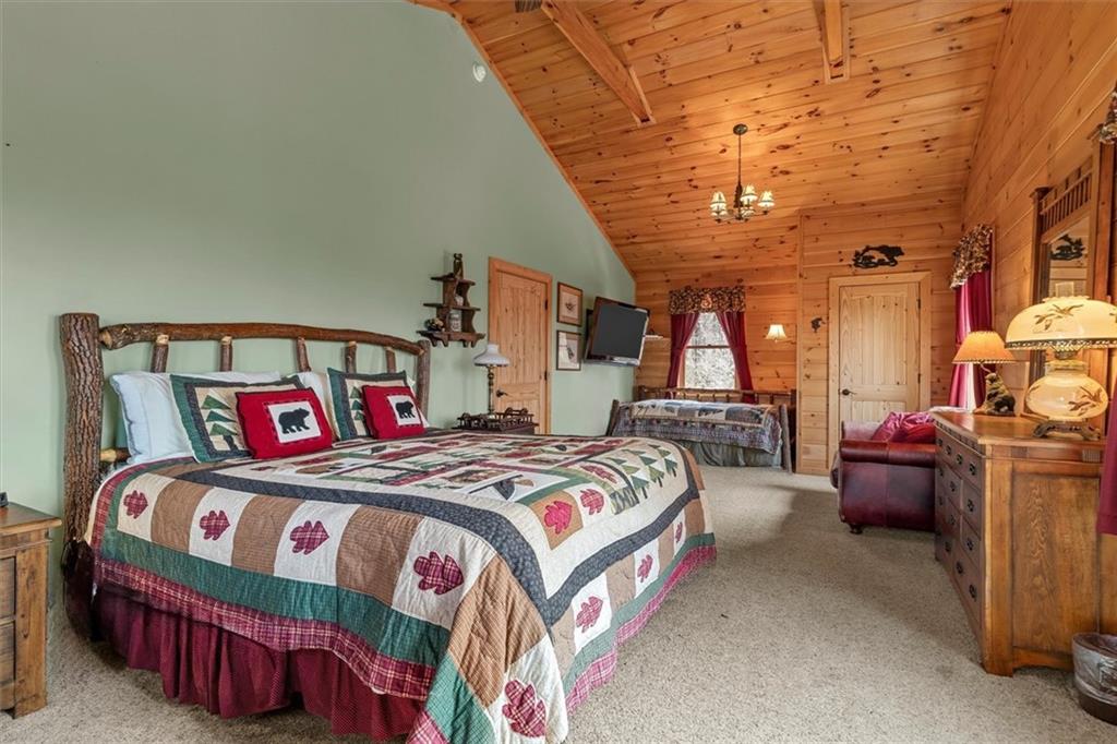 881 Fox Mountain Road Cherry Log, GA 30522 - Photo 44 of 65 a bedroom with a bed and a chandelier