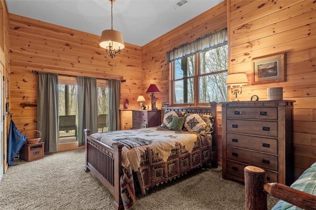 881 Fox Mountain Road Cherry Log, GA 30522 - Photo 58 of 65 a bedroom with a bed and a chandelier