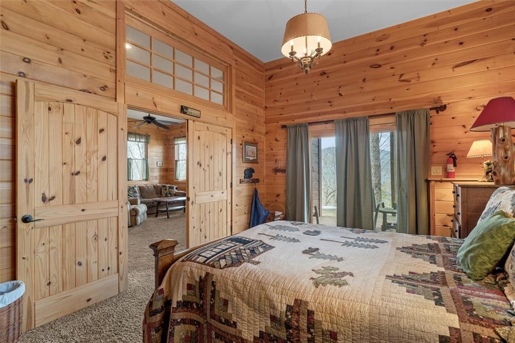 881 Fox Mountain Road Cherry Log, GA 30522 - Photo 59 of 65 a bedroom with a bed and a chandelier